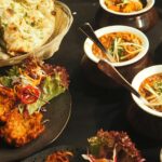 A mouth-watering display of Indian cuisine featuring naan, curry, and pakoras perfect for a delightful meal.